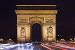 Traffic around the Arc de Triomphe at night.  Paris, France.