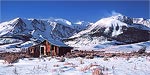 Wind blows fresh snow off peaks on a cold, sunny January morning.  Mono County, CA.