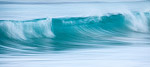 A wave breaking in the turquise water at Ha'ena Beach on the North Shore of Kauai, HI.